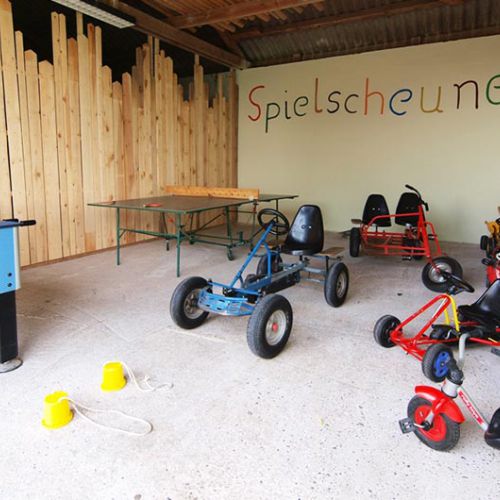 Spielscheune mit vielen Spielsachen und Fahrzeugen für Kinder