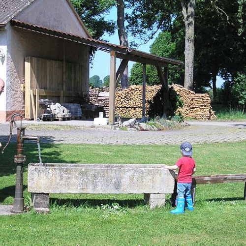 Eine Familie spielt mit einer Wasserpumpe